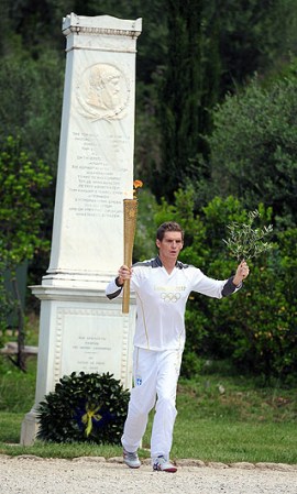 Después de la ceremonia, con una coreografía bien organizada, la sacerdotisa entregó la llama al primer portador de la antorcha, el nadador griego y medallista olímpico de plata Spyros Gianniotis.