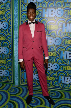 J. Alexander con un traje muy peculiar en color rosa con un saco que pareciera le queda corto de las mangas y con un peinado muy peculiar.
