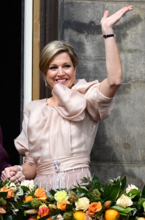 La Reina Maxima saluda desde el balcón del Palacio Real. Luce radiante y feliz.