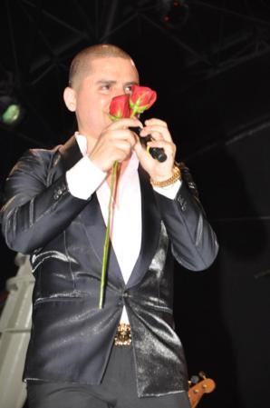 Un primer plano del cantante, luciendo muy elegante con un traje de color negro.
