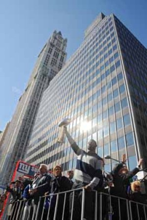 Justin Tuck de los New York Giants levanta el trofeo Vince Lombardi durante la parada en la ciudad de Nueva York.
