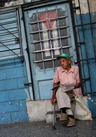 Julio Martínez Estrada, conductor de locomotoras retirado, vende ejemplares de "Granma" en Luyanó, un barrio de La Habana.