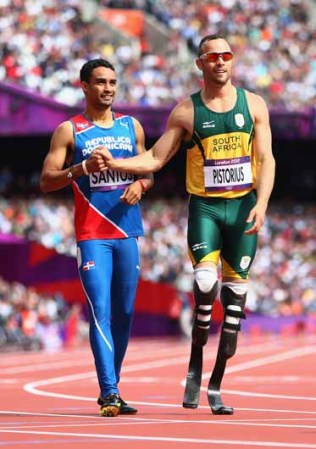 Luguelin Santos, de la República Dominicana, felicita a Oscar Pistorius, de Sudáfrica, tras la competencia en la que por primera vez participó una persona con las extremidades amputadas.