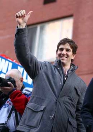 Eli Manning #10 alza su pulgar a la multitud en signo de victoria.