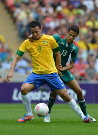 Leandro Damiao de Brasil se disputa la bola con Diego Reyes de México.