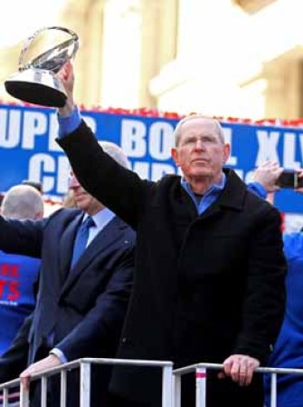 El entrenador principal de los Giants Tom Coughlin muestra el trofeo de Vince Lombardi tras ganar el Súper Bowl.