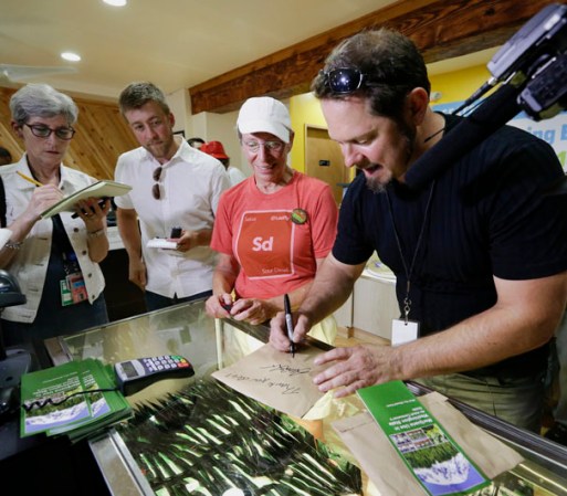 Deb Greene recibe una nota conmemorativa del dueño de la tienda de marihuana Cannabis City, James Lathrop.