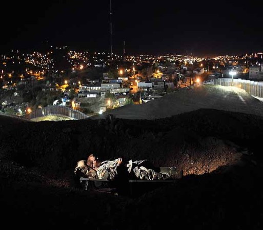 NOGALES, AZ - JUNE 22: U.S. Army National Guardsman Pfc. Philip Moore, 28, rests during a "down time" shift overlooking the border fence with Mexico on June 22, 2011 in Nogales, Arizona. The Pentagon recently extended the deployment of some 1,200 guardsmen who were deployed last year to assist with border security on the U.S.-Mexico border until September 30. Soldiers at Early Identification Team (EIT) observation posts in Nogales work 24 hour shifts, each taking turns resting for 4 hours during the night. The National Guard troops are strictly on surveillance duty, although they are armed and have been credited with helping U.S. Border Patrol agents arrest up to 17,000 illegal immigrants crossing into the United States. (Photo by John Moore/Getty Images)