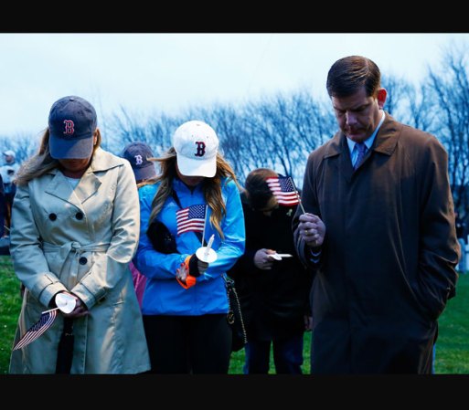 El alcalde de Boston, Marty Walsh, y su familia inclinan su rostro y guardan un minuto de silencio durante la vigilia en el parque Garvey en conmemoración al primer aniversario de los atentados.