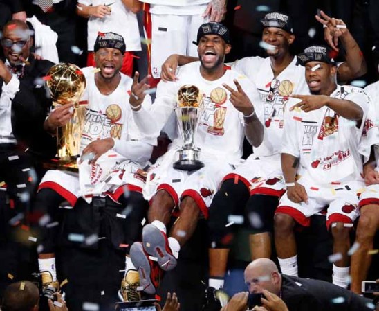 El equipo de los Miami Heat celebran con la foto de la victoria junto al trofeo de campeones de la NBA 2013, en medio de una euforia generalizada en la AAA.