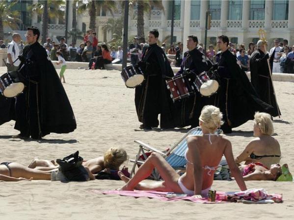 Valencia, España: Bañistas observan la procesión de la cofradía Cristo Salvador y Protector .