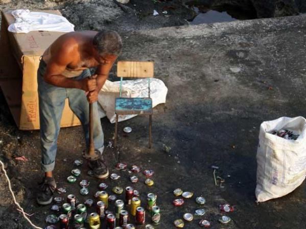 27 DE MAYO, 2009: Un hombre mete latas de aluminio en una bolsa, para venderlas, en las cercanías del Malecón.