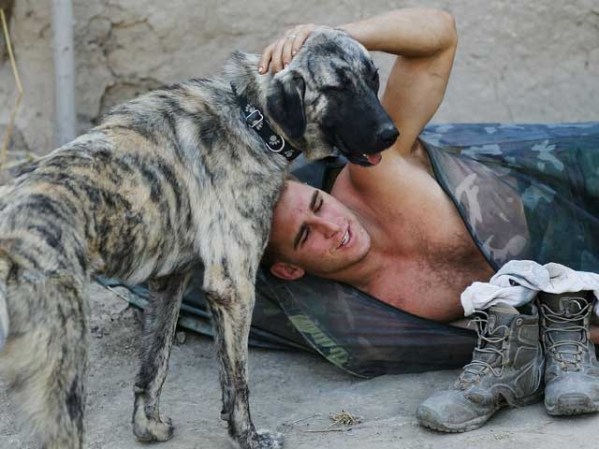 El sargento John Barton de la 82 Aerotransportada juega con la mascota de su brigada Ray-Ray en la zona de Bala Murghab.