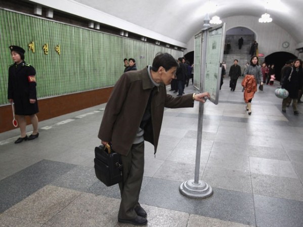 Un hombre lee el diario oficial del país en una estación de metro situada 1,000 metros bajo tierra.