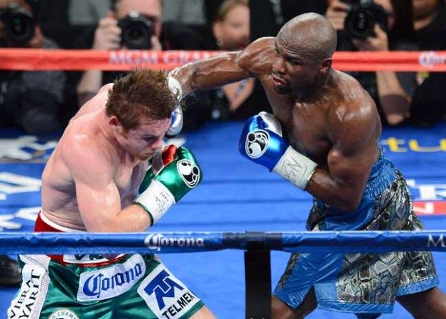 LAS VEGAS, NV - SEPTEMBER 14: Floyd Mayweather Jr. (R) hits Canelo Alvarez in the fifth round of their WBC/WBA 154-pound title fight at the MGM Grand Garden Arena on September 14, 2013 in Las Vegas, Nevada. Mayweather won by majority decision. (Photo by Ethan Miller/Getty Images)