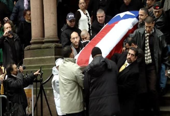 Tras un recorrido por el barrio, el féretro -cubierto con la bandera de Puerto Rico- fue subido por la escalinata.