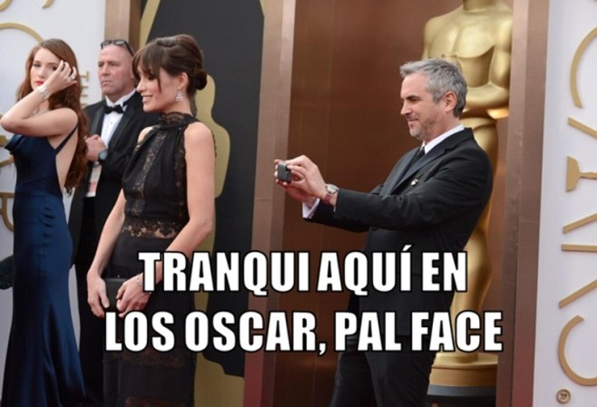 Alfonso Cuarón como si fuera a subir la foto en su Facebook.