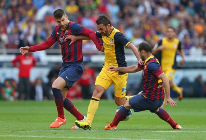 BARCELONA, SPAIN - MAY 17: Adrian Lopez of Club Atletico de Madrid is tackled by Gerard Pique and Javier Mascherano of FC Barcelona during the La Liga match between FC Barcelona and Club Atletico de Madrid at Camp Nou on May 17, 2014 in Barcelona, Spain. (Photo by Alex Livesey/Getty Images)