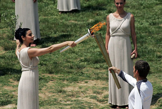 ATHENS, GREECE - MAY 10: High Priestess Ino Menegaki lights the London 2012 Olympic Torch during the Lighting Ceremony of the Olympic Flame at Ancient Olympia on May 10, 2012 in Olympia, Greece. (Photo by Milos Bicanski/Getty Images)