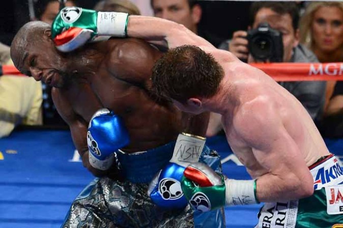 LAS VEGAS, NV - SEPTEMBER 14: Canelo Alvarez (R) hits Floyd Mayweather Jr. in the sixth round of their WBC/WBA 154-pound title fight at the MGM Grand Garden Arena on September 14, 2013 in Las Vegas, Nevada. Mayweather won by majority decision. (Photo by Ethan Miller/Getty Images)