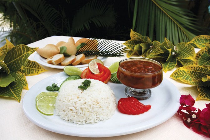 Arroz acompañado con habichuelas rojas en un ambiente tropical.