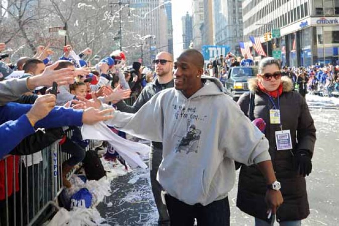 Varios jugadores de los Giants saludan a los fanáticos neoyorquinos durante el desfile de bienvenida en Nueva York.