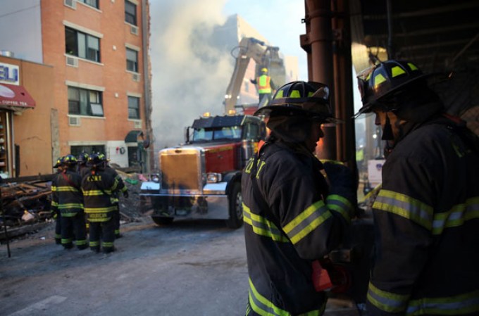 NEW YORK, NY - MARCH 13: Firemen stand by the smoking site of an explosion in East Harlem on March 13, 2014 in New York City. At least 7 people were killed, according to reports, in Wednesday's explosion which collapsed two buildings on Park Avenue at 116th Street. (Photo by John Moore/Getty Images)
