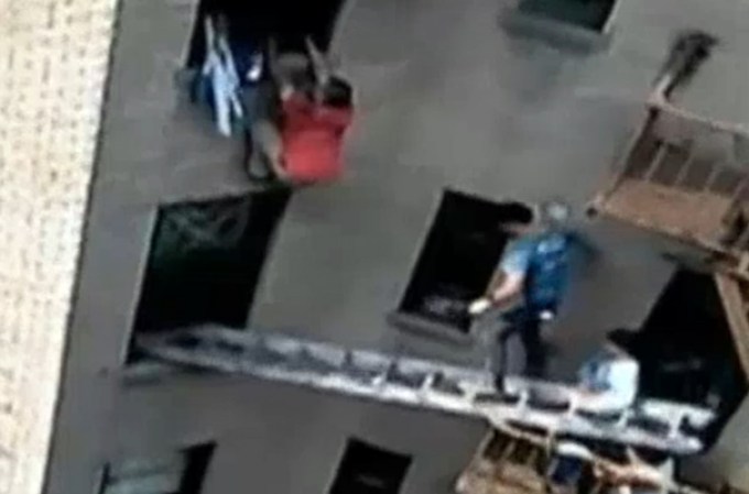Dos samaritanos notaron a la víctima pidiendo auxilio desesperadamente desde la ventana del quinto piso en llamas.