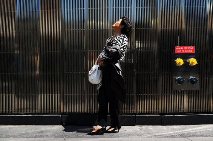 NEW YORK, NY - MAY 02: A woman watches as the 408-foot spire is hoisted onto a temporary platform on the top of One World Trade Center on May 2, 2013 in New York City. When bolted into place at a later date, the spire will make One World Trade Center the tallest building in the Western Hemisphere.The raising of the spire, which comes on the second anniversary of the death of Osama bin Laden, will make One World Trade Center 1,776 feet tall. One World Trade Center is built on the site where the September 11, 2001 attacks toppled the original World Trade Center towers. (Photo by Spencer Platt/Getty Images)