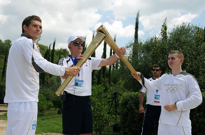 ATHENS, GREECE - MAY 10: Alex Loukas from Britain lights the London 2012 Olympic Torch from Spyros Gianniotis of Greece during the Lighting Ceremony of the Olympic Flame at Ancient Olympia on May 10, 2012 in Olympia, Greece. (Photo by Jamie McDonald/Getty Images)