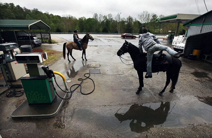 BOONEVILLE, KY - APRIL 21: Horse riders prepare to depart after a break at a gas station during the Owsley County Saddle Club trail ride on April 21, 2012 in Booneville, Kentucky. The trail ride attracts riders from outside the county who contribute much needed revenue. Daniel Boone once camped in the Appalachian mountain hamlet of Owsley County which remains mostly populated by descendants of settlers to this day. The 2010 U.S. Census listed Owsley County as having the lowest median household income in the country outside of Puerto Rico, with 41.5% of residents living below the poverty line. Familial and community bonds run deep, with a populace that shares a collective historical and cultural legacy uncommon in most parts of the country. However, the community of around 5,000 struggles with a lack of jobs due to the decline in coal, tobacco and lumber industries along with health issues including drug addiction without effective treatment. (Photo by Mario Tama/Getty Images)