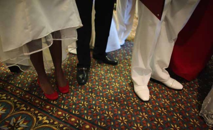 WEST PALM BEACH, FL - FEBRUARY 14: Brides and grooms participate in a group Valentine's day wedding at the National Croquet Center on February 14, 2013 in West Palm Beach, Florida. The group wedding ceremony is put on by the Palm Beach Country Clerk & Comptroller's office and approximately 40 couples tied the knot. (Photo by Joe Raedle/Getty Images)