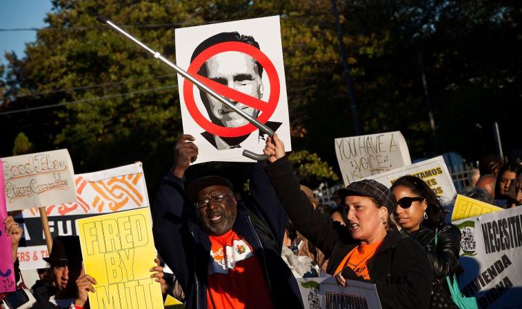 Manifestantes se muestran en contra de Mitt Romney.