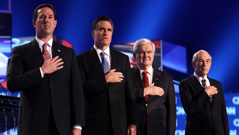 Los aspirantes republicanos a la presidencia (de izquierda a derecha) Rick Santorum, Mitt Romney, Newt Gingrich y Ron Paul colocan sus manos sobre sus corazones mientras suena el himno nacional previo al debate este jueves en Carolina del Sur.