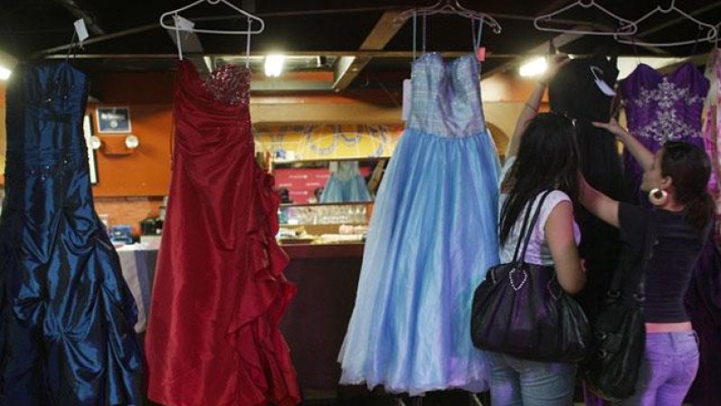 Estudiantes de secundaria en Nueva York examinan vestidos del "prom" que recibirán gratis para poder asistir a la fiesta de graduación de sus escuelas.