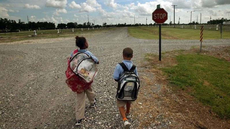 Dos niños caminan a la escuela desde su casa móvil en Port Sulphur, Luisiana.