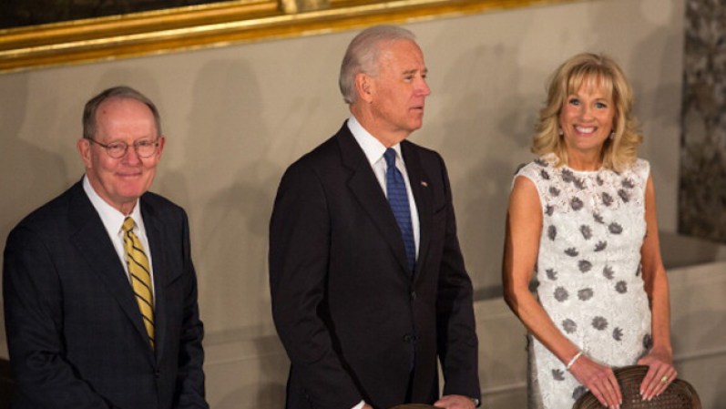Jill Biden, la esposa del Vice Presidente, luce un vestido claro, al cuerpo, con flores incrustadas.