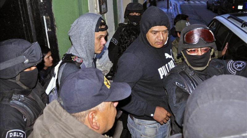 Policías bolivianos escoltan a los hinchas brasileños detenidos por el caso del joven boliviano muerto en el partido por la Copa Libertadores.
