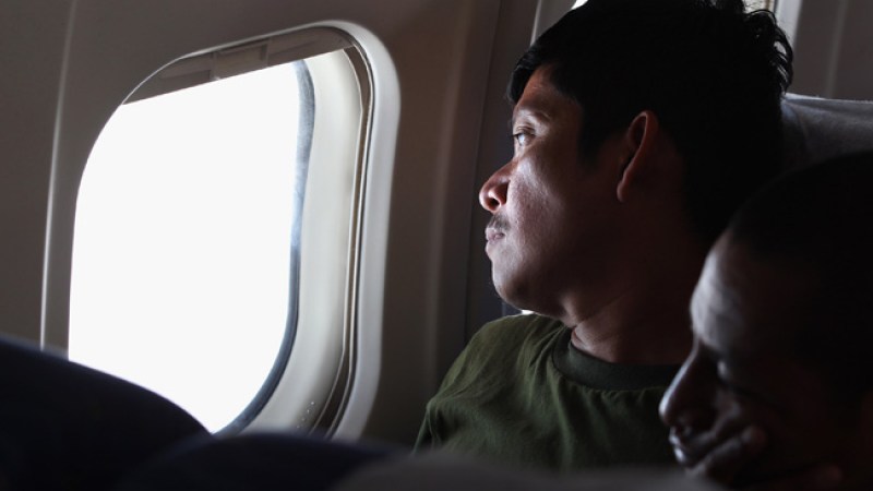 Fidel Rodriguez, de Guatemala, se asoma a la ventana del avión al aterrizar en el avión que lo deportó desde Arizona hasta su país.