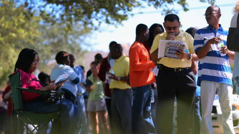 Decenas de personas esperan en línea para votar en la Biblioteca Pública de North Miami, en Florida, durante el periodo adelantado de votaciones.