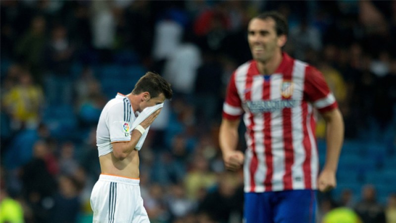 Mientras los jugadores del Atlético celebran su victoria, los del Madrid muestran su desconsuelo.