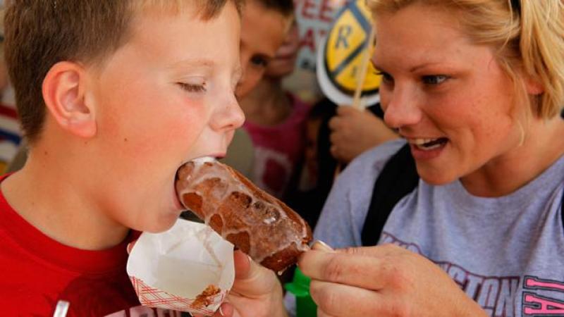 Una madre da a su hijo de comer mantequilla frita, en Iowa. Según Womens Health, los alimentos fritos aumentan el riesgo de enfermedades cardíacas.