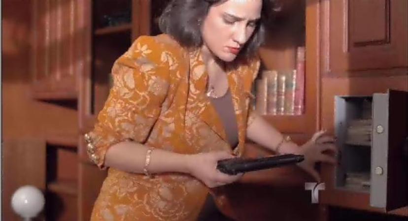 Patricia saca una pistola de la caja fuerte de Escobar.