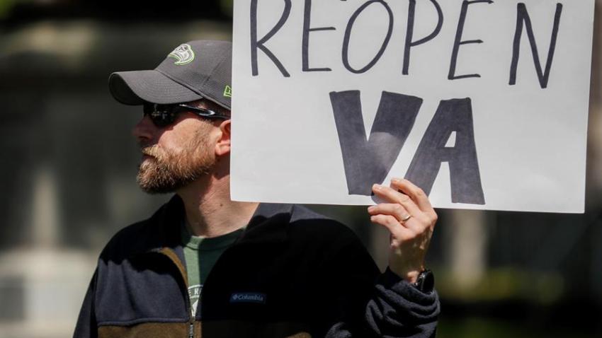 Un hombre sostiene una pancarta durante una protesta contra el confinamiento en Richmond, Virginia.