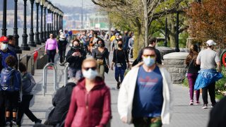 In this April 25, 2020, file photo, a large crowd of people enjoy the weather at Hudson River Park in New York City despite a stay at home order in place during coronavirus pandemic.