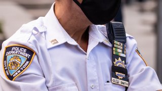 A New York Police Department (NYPD) officer wearing a mask has his badge number covered up with a black strip of fabric in Columbus Circle.