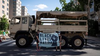 Dos manifestantes frente a un vehículo militar durante las protestas contra el racismo en Washington, D.C. a principios de junio. EFE