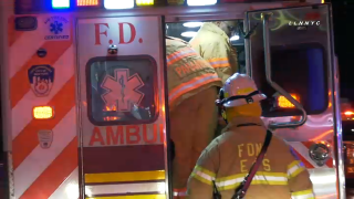 firefighters gather around ambulance