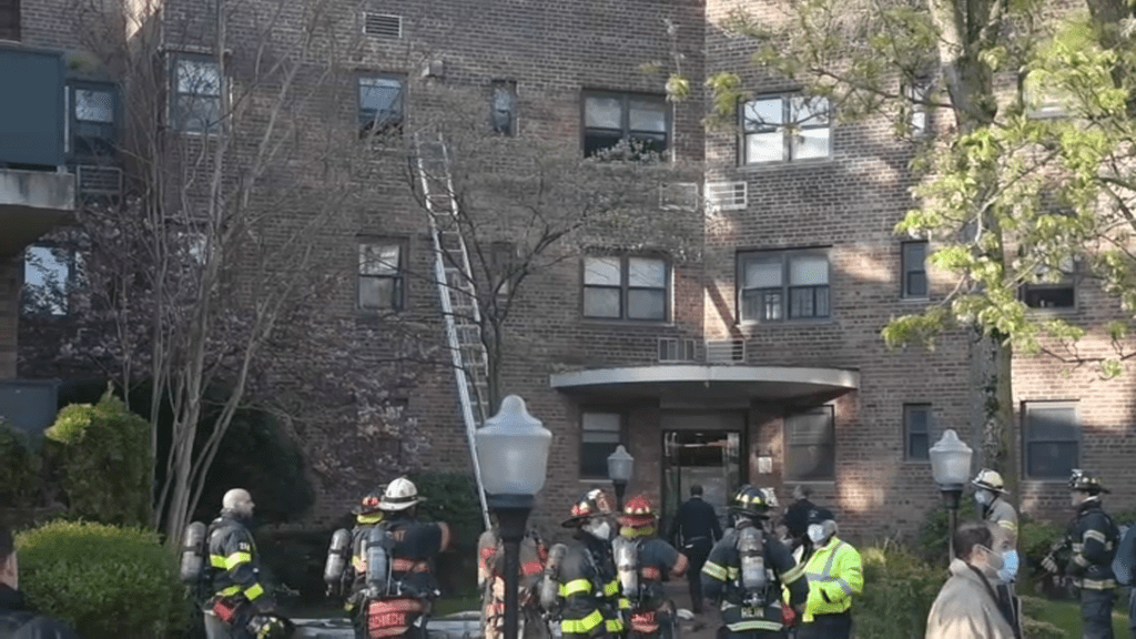 firefighters stand outside long island apartment