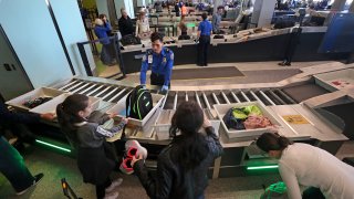 Officials from the Transportation Security Administration and Massachusetts Port Authority introduce the new automated screening lanes at Logan Airport's Terminal C in Boston on Dec. 20, 2017